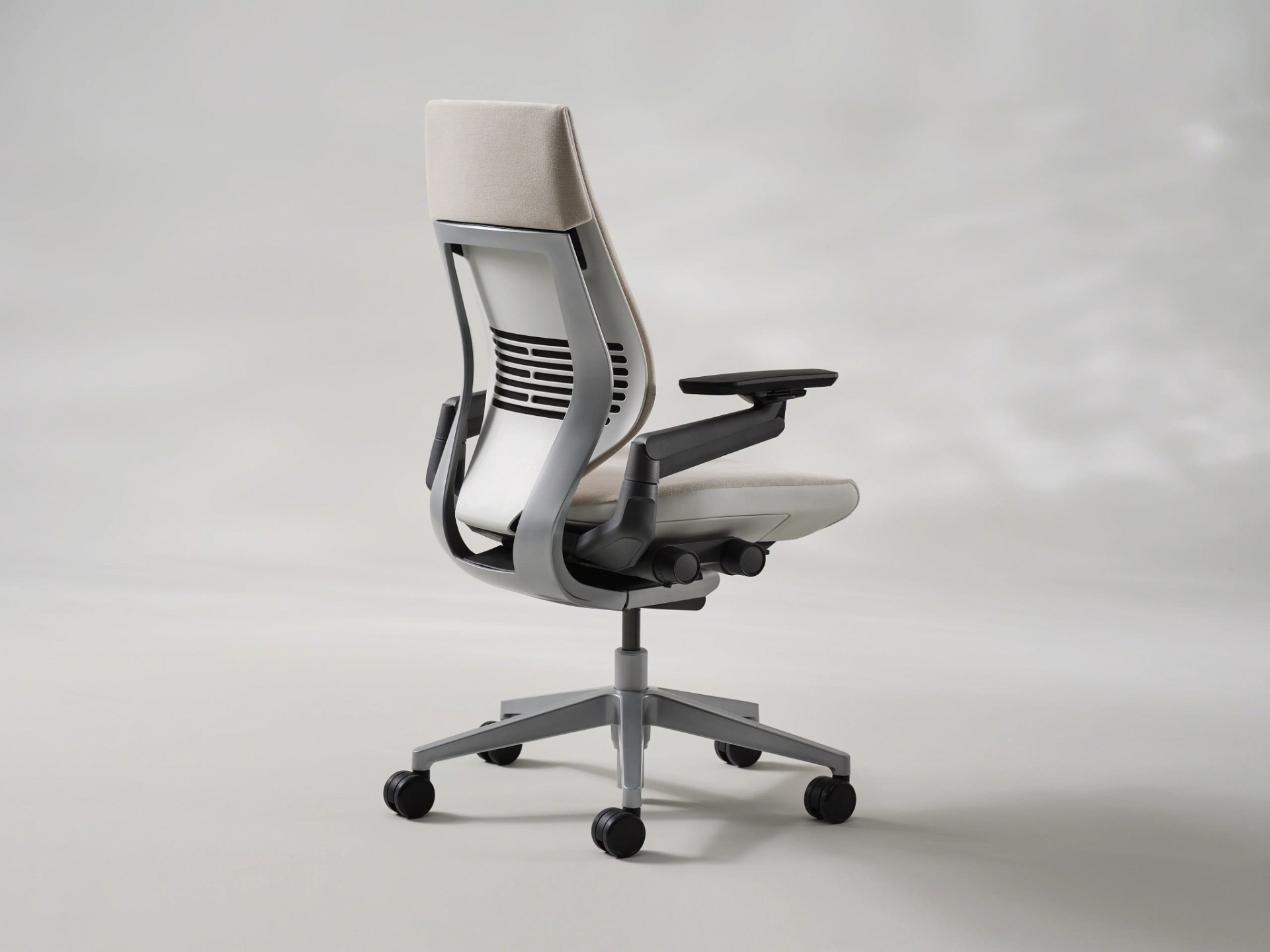 Steelcase Gesture office chair in dark grey, showing 360-degree armrests, contoured seat, and synchronized recline mechanism